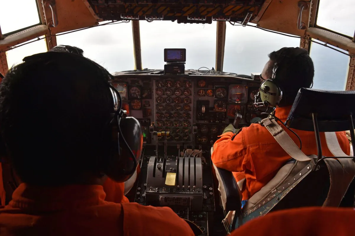 Indonesian air force personnel fly a C-130 Hercules aircraft over the Java Sea during search and rescue operations for missing AirAsia flight QZ8501 on Dec. 29, 2014. (Bay Ismoyo/AFP/Getty Images)