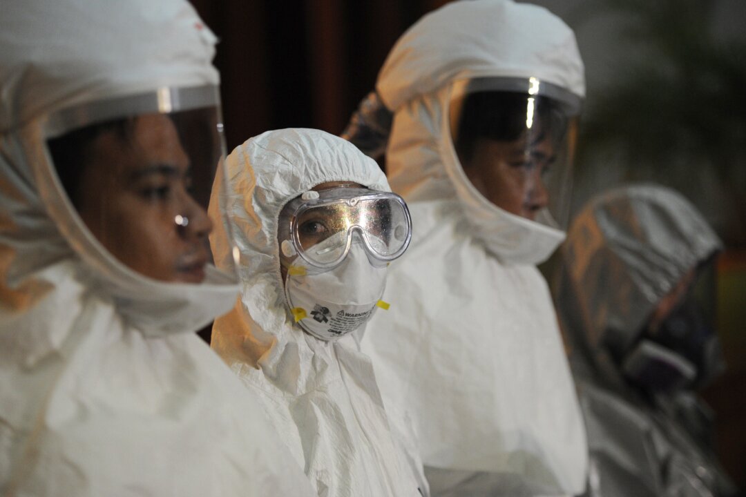 Philippine medical workers display protective suits during a press conference by health officials on the country's preparedness against Ebola, at the Research Institute for Tropical Medicine (RITM) facilities in Alabang town, suburban Manila, on Oct. 21, 2014. (Ted Aljibe/AFP/Getty Images)