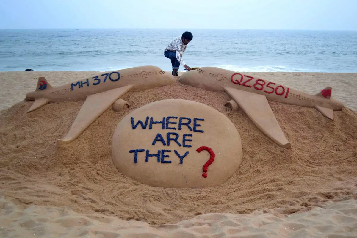 Indian sand artist Sudarsan Pattnaik gives the final touches to his sand sculpture portraying two missing aircraft, Air Asia QZ8501 and Malayasia Airlines MH370 on Golden Sea Beach at Puri, east of Bhubaneswar on Monday. (STRDEL/AFP/Getty Images)
