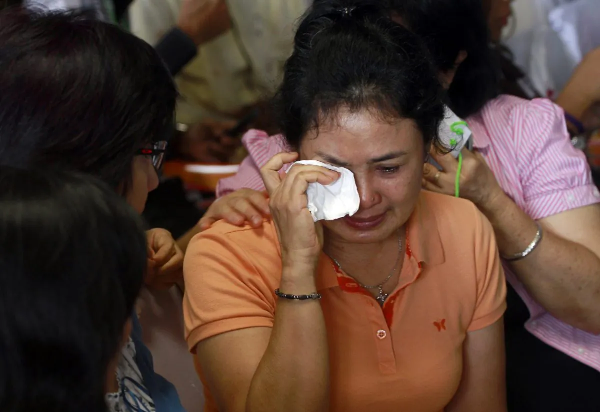 A relative of passengers of the missing AirAsia flight QZ8501 weeps as they wait at the crisis center at Juanda International Airport in Surabaya, East Java, Indonesia, Tuesday, Dec. 30, 2014. Several pieces of debris have been spotted floating in the sea off Borneo island, possibly linked to the missing AirAsia jetliner, an Indonesia National Search and Rescue spokesman said Tuesday.(AP Photo/Firdia Lisnawati)