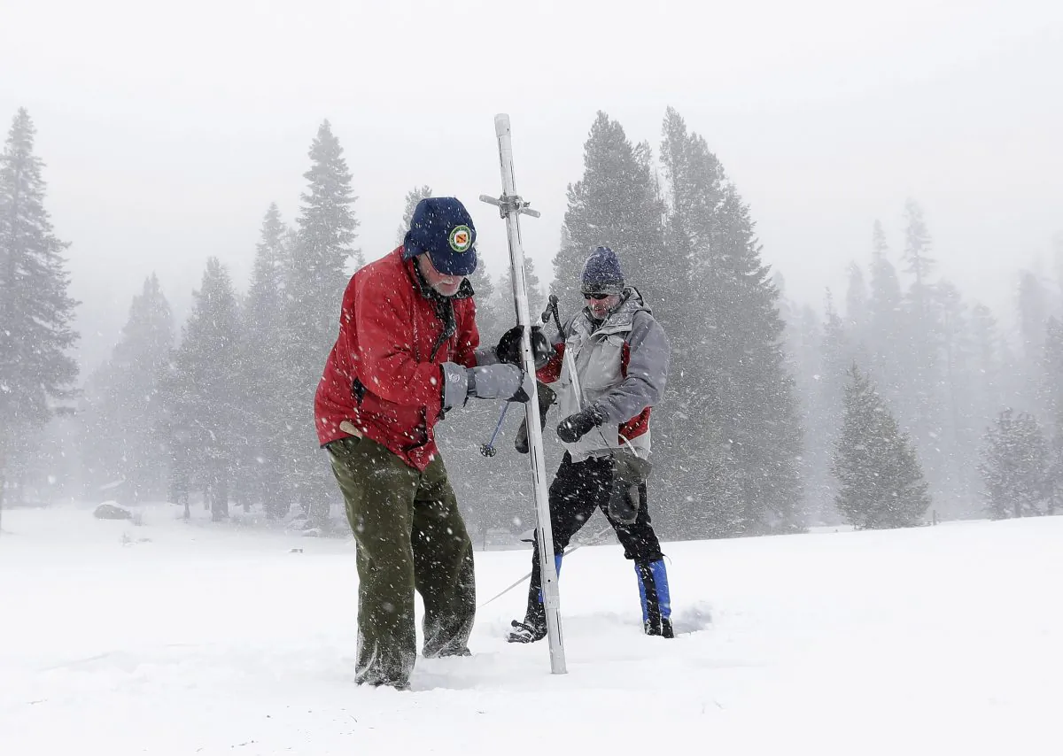 Frank Gehrke (L), chief of California Cooperative Snow Surveys Program for the Department of Water Resources, pulls the snow depth survey pole from the snow pack as he conducts the first snow survey of the season at Echo Summit, Calif., Tuesday, Dec. 30, 2014. The survey showed the snow pack to to be 21.3 inches deep with a water content of 4.8 inches, which is 33 percent of normal for this site at this time of year. At right is Dave Schmalenberger, of the Eat Bay Municipal Utility District, who accompanied Gehrke on the survey. (AP Photo/Rich Pedroncelli)
