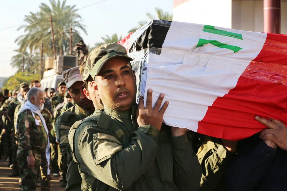 Mourners carry the coffin of retired Brig. Gen. Abbas Hassan Jabr, a senior member of the Badr Brigades, a Shiite militia, who was killed during a battle against the Islamic State extremist group, during his funeral in Baghdad Iraq, Thursday, Dec. 30, 2014. (AP Photo/Hadi Mizban)