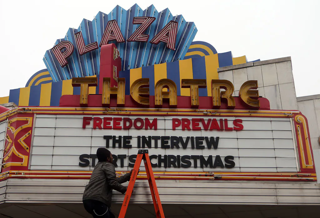 Brandon Delaney, general manager of the Plaza Theatre, in Atlanta, Ga., finishes hanging the marquis on Dec. 23 to announce that the theater will be showing “The Interview.” The film’s video-on-demand debut coincided with its theatrical release, a first for a major studio picture. (AP Photo/Atlanta Journal-Constitution, Ben Gray)