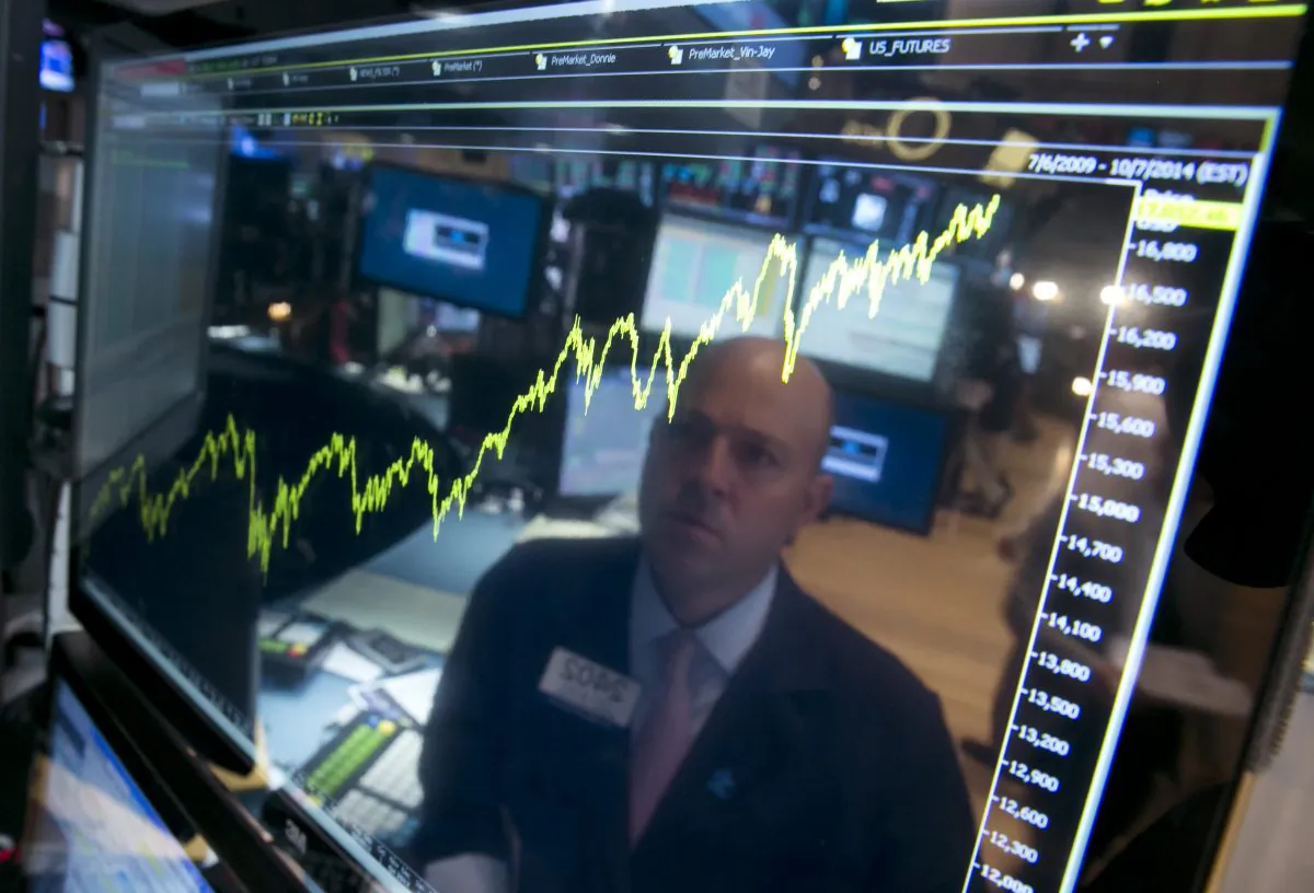 In this Thursday, July 3, 2014, file photo, specialist Jay Woods is reflected in a screen at his post that shows five years of the Dow Jones industrial average, on the floor of the New York Stock Exchange. (AP Photo/Richard Drew)