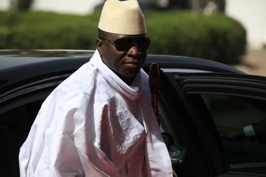 Gambia's President Yahya Jammeh arrives for a summit to address a seminar on security during an event marking the centenary of the unification of Nigeria's north and south in Abuja, Nigeria, on Feb. 27, 2014. Heavy gunfire is reported Tuesday Dec. 30, 2014, near the presidential palace in Gambia, according to local residents, raising the specter of a coup attempt while the longtime ruler is currently visiting France, state media reported. On Tuesday, soldiers linked to his presidential guard were believed to be involved in the fighting, according to witnesses who spoke on condition of anonymity for fear of reprisals. (AP Photo/Sunday Alamba)