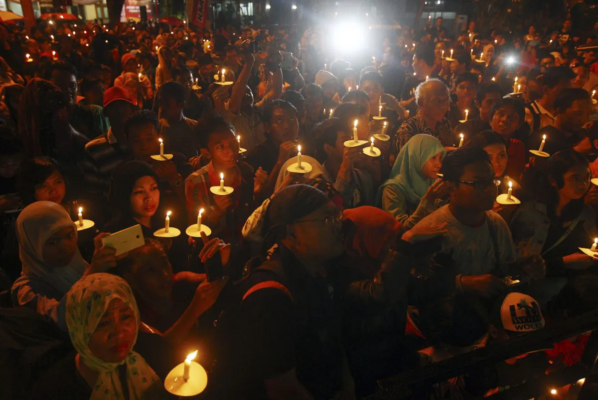 Indonesians hold candles to pray for the victims of AirAsia Flight 8501 in Surabaya, Indonesia, Wednesday, Dec. 31, 2014. Bad weather hindered efforts to recover victims of the jetliner on Wednesday, and sent wreckage drifting far from the crash site, as grieving relatives prayed for strength to endure their losses. (AP Photo/Firdia Lisnawati)