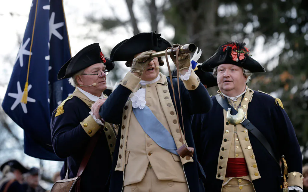 George Washington (C), played by John Godzieba, looks toward New Jersey through a scope during the 62nd annual reenactment of Washington's daring Christmas 1776 crossing of the river - the trek that turned the tide of the Revolutionary War, on Thursday, Dec. 25, 2014, in Washington Crossing, Pa. (AP Photo/Mel Evans)