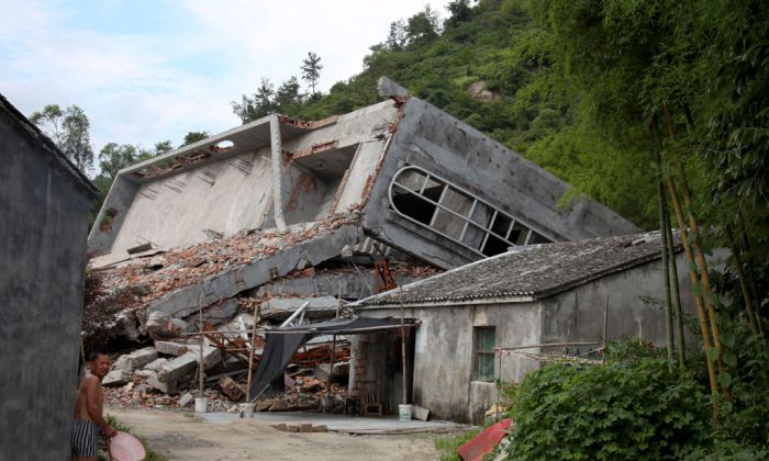 A man stands near the razed remains of a Catholic church in a village in Pingyang county of Wenzhou in eastern China's Zhejiang Province on July 16, 2014. (AP Photo/Didi Tang)