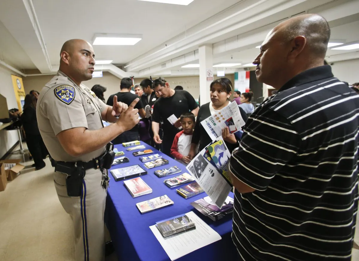 In this file photo, a California Highway Patrol officer explains to immigrants the process of getting a driver's license during an information session at the Mexican Consulate, in San Diego, Calif., on April 23, 2014. (AP Photo/Lenny Ignelzi,File)