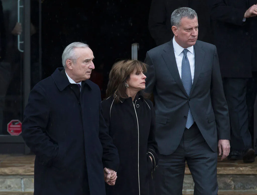 (L-R) NYPD Commissioner Bill Bratton, Rikki Klieman, Bratton's wife, and NYC Mayor Bill de Blasio, exit the wake of NYPD Officer Wenjian Liu at Aievoli Funeral Home, Saturday, Jan. 3, 2015, in the Brooklyn borough of New York. (AP Photo/John Minchillo)
