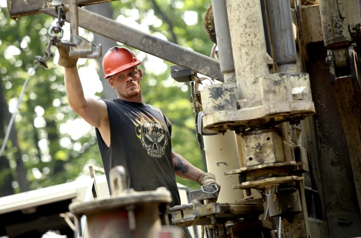 Linn Energy LLC relief driller Jim Williams loads drill rods onto a drill rig in Indiana, Pa. in 2006. (Andrew Rush/AP)