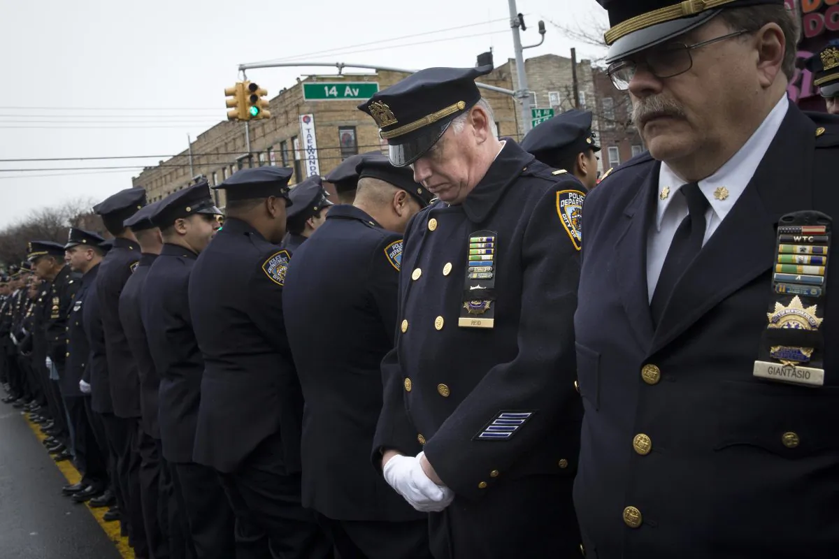 Some police officers turn their backs as Mayor Bill de Blasio speaks during the funeral of New York Police Department Officer Wenjian Liu at Aievoli Funeral Home in the Brooklyn borough of New York on Sunday, Jan. 4, 2015. Liu and his partner, officer Rafael Ramos, were killed Dec. 20 as they sat in their patrol car on a Brooklyn street. (AP Photo/John Minchillo)