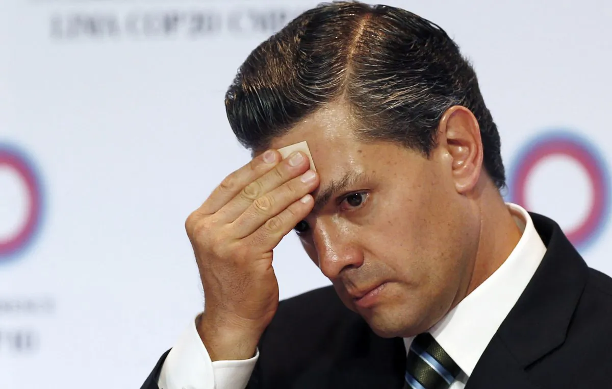 Mexico's President Enrique Pena Nieto wipes sweat from his brow during a signing ceremony among the Pacific Alliance at the Climate Change Conference in Lima, Peru, on Dec. 10, 2014. (AP Photo/Juan Karita)