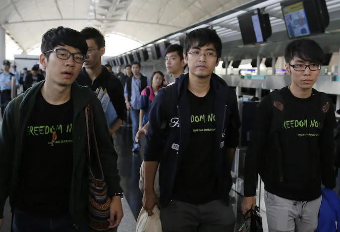 Hong Kong Federation of Students leader Alex Chow (C) committee members Nathan Law (L) and Eason Chung (R) were denied permission to travel to Beijing at Hong Kong International Airport on Nov. 15, 2014. (AP Photo/Vincent Yu)