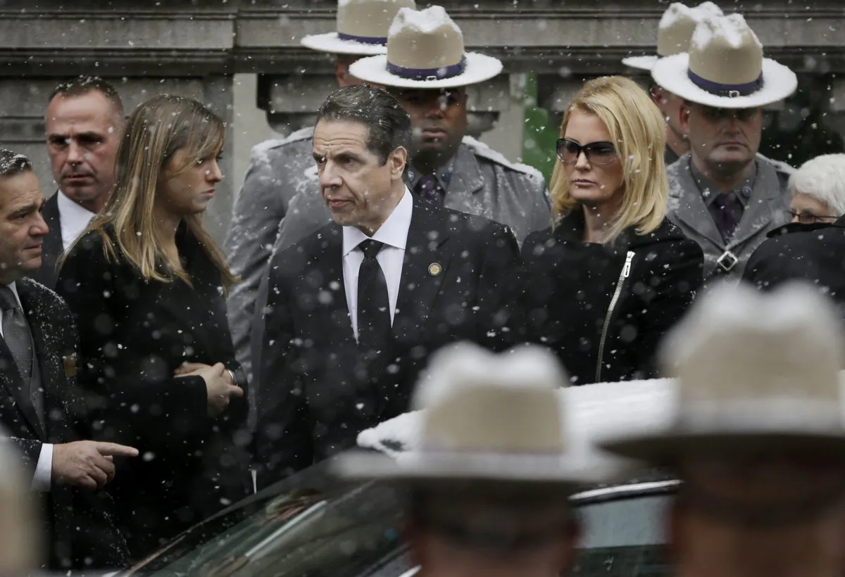 New York Gov. Andrew Cuomo (C) waits with his girlfriend, Sandra Lee, while the body of his father, Mario Cuomo, is carried into Church of St. Ignatius Loyola for his funeral in New York, Tuesday, Jan. 6, 2015. Cuomo, 82, died in his Manhattan home on Jan. 1, hours after his son was inaugurated for a second term. (AP Photo/Seth Wenig)