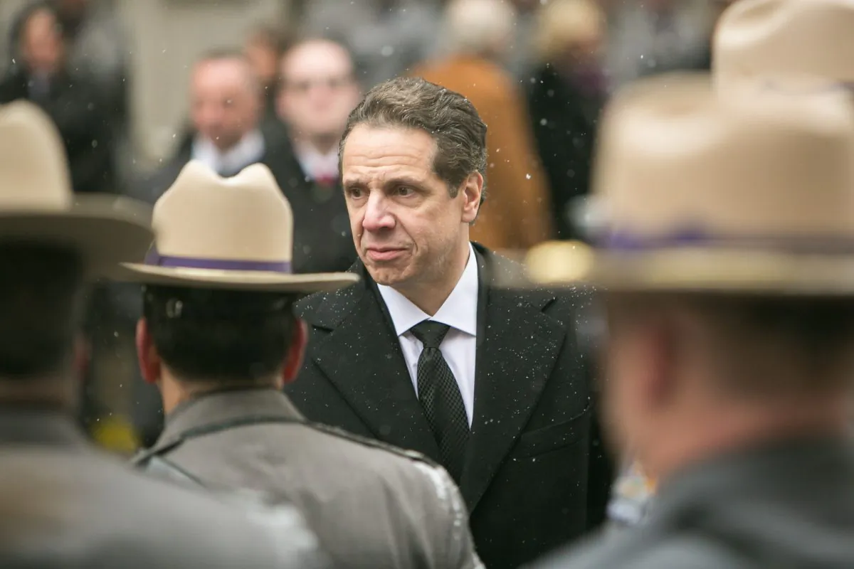 New York Governor Andrew Cuomo holds his mother's hand as they walk behind the casket of his father, Mario Cuomo, following the funeral service in Manhattan on Jan. 6, 2015. (Benjamin Chasteen/Epoch Times) 