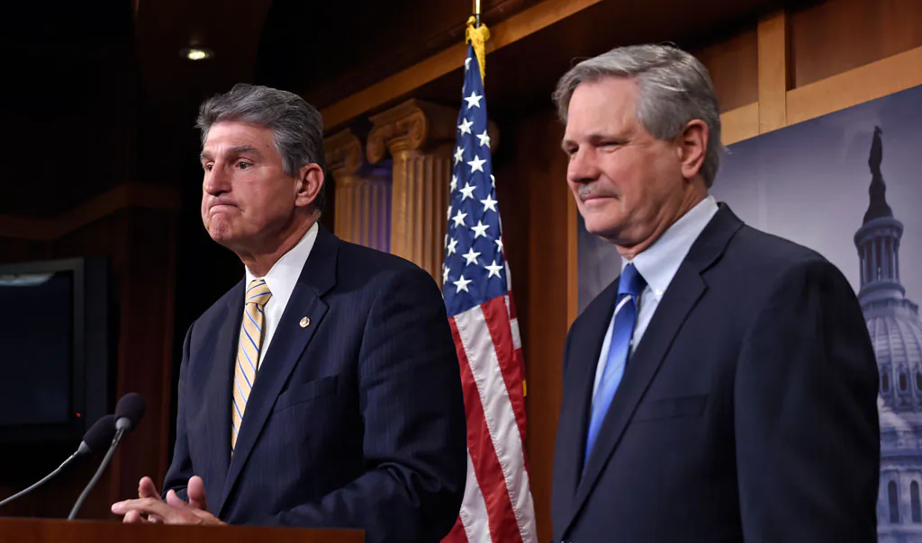 Sen. John Hoeven (R-N.D.) listens at right as Sen. Joe Manchin (D-W.Va.) speaks during a news conference on Capitol Hill in Washington, Jan. 6, 2015, where they discussed their plan to introduce legislation to approve the Keystone XL pipeline project. (AP Photo/Susan Walsh)
