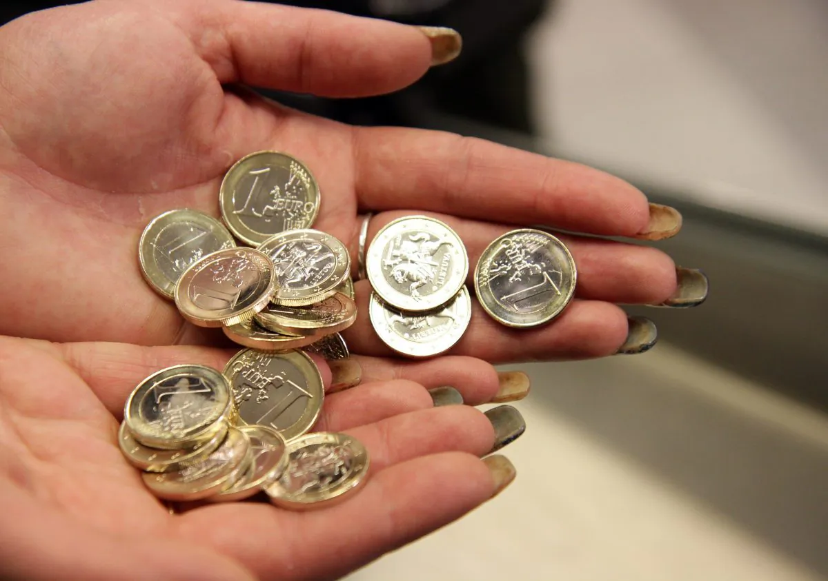 Lithuania became the 19th nation to join the eurozone when it did so on Jan. 1, 2015. A cashier is shown here in Vilnius, Lithuania inspecting euro coins. (Petras Malukas/AFP/Getty Images)