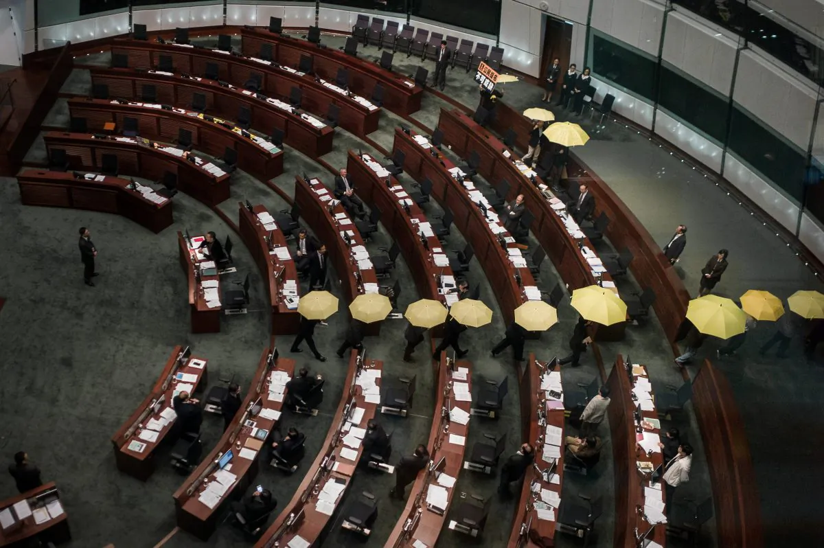Pro-democracy lawmakers carrying yellow umbrellas—the symbol of the pro-democracy movement—walk out of the legislative chamber as the consultation document is about to be presented in Hong Kong on Jan. 7, 2015.  (Aaron Tam/AFP/Getty Images)