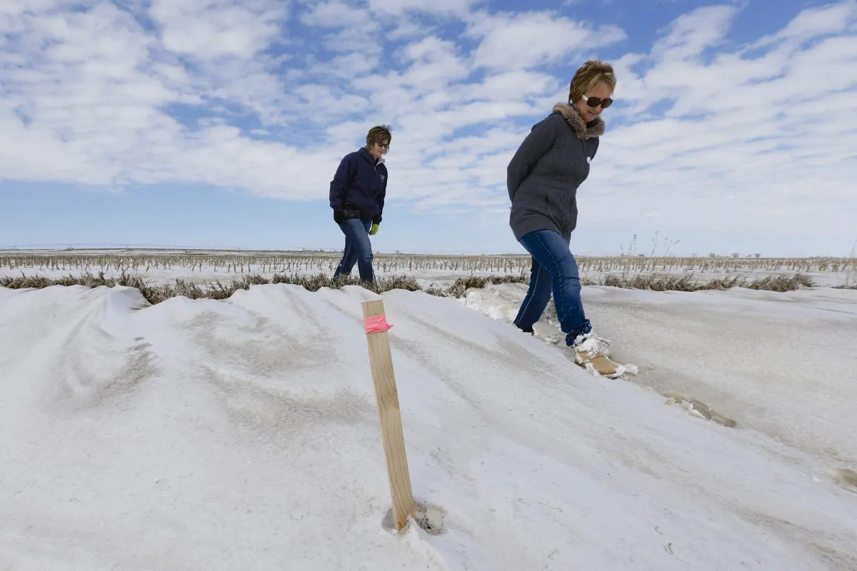 Sisters Jenni Harrington (L) and Abbi Kleinschmidt pass a stake that marks the proposed route of the Keystone XL pipeline on Harrington's property near Bradshaw, Neb., on March 11, 2013. The Republican-led Congress appears ready to approve the Keystone XL oil pipeline but Harrington says they won't sell out the next generation for any amount, not even $50 million. No matter what actions are taken in Washington, the entire 1,179-mile project could be delayed until the state of Nebraska signs off on the route. (AP Photo/Nati Harnik)
