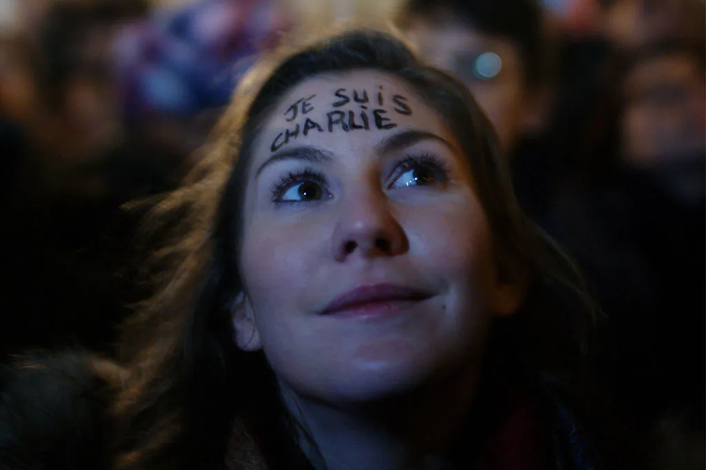 The inscription "I am Charlie" is written on the fronthead of a woman as she attends a gathering to pay respect for the victims of a terror attack against a satirical newspaper, in Paris, France, Wednesday, Jan. 7, 2015. Masked gunmen shouting "Allahu akbar!" stormed the Paris offices of a satirical newspaper Wednesday, killing 12 people, including the paper's editor, before escaping in a getaway car. It was France's deadliest terror attack in living memory. (AP Photo/Thibault Camus)