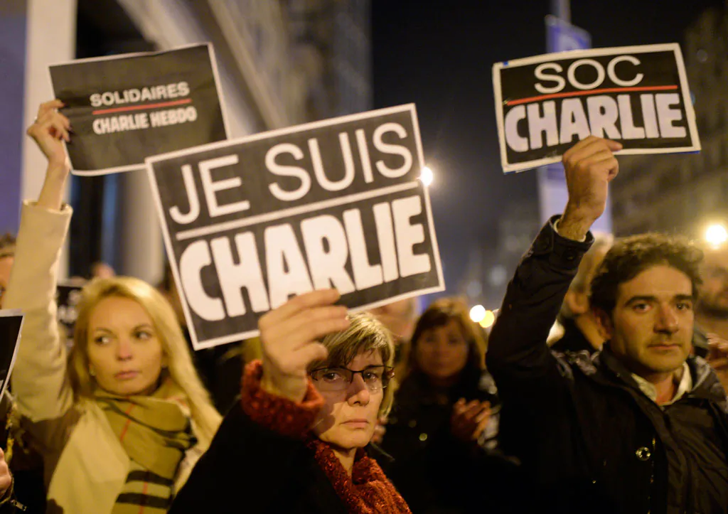 People attend a demonstration in solidarity with those killed in an attack at the Paris offices of weekly newspaper Charlie Hebdo, at the French Consulate in Barcelona, Spain, Wednesday, Jan 7, 2015. Masked gunmen stormed the Paris offices of a weekly newspaper that caricatured the Prophet Muhammad, methodically killing 12 people Wednesday, including the editor, before escaping in a car. It was France's deadliest postwar terrorist attack. (AP Photo/Manu Fernandez)