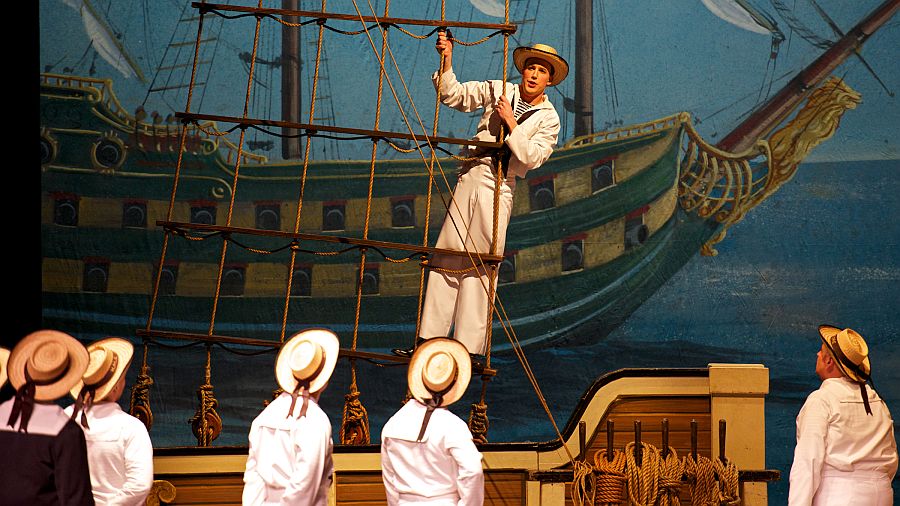 Cameron Smith as Ralph Rackstraw (played by Daniel Greenwood in the reviewed production) and a chorus of sailors in the New York Gilbert & Sullivan Players production of “H.M.S. Pinafore.” (William Reynolds)