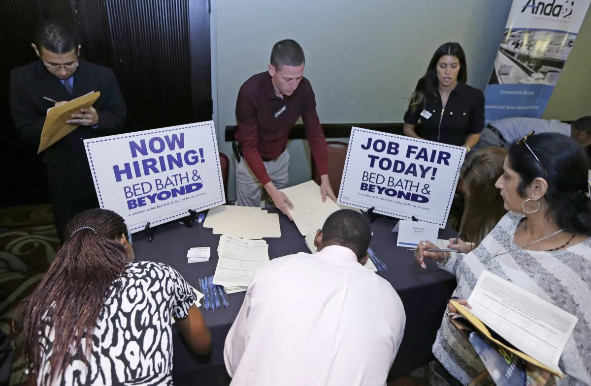 Job seekers fill out a job applications at a Bed Bath and Beyond table at a job fair in Miami Lakes, Fla., on Oct. 22, 2014. (AP Photo/Alan Diaz)