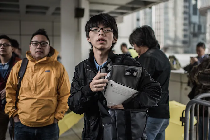 Hong Kong student activist Joshua Wong (C) is pictured outside the High Court in Hong Kong on Jan. 8, 2015. (Philippe Lopez/AFP/Getty Images)