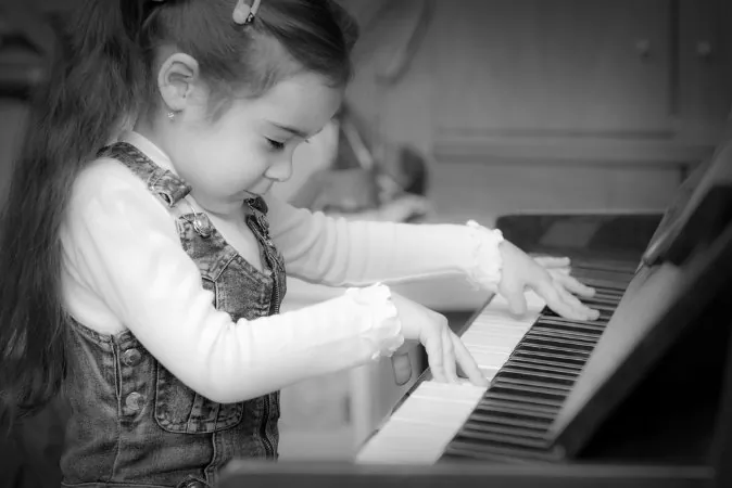 A stock photo of a child playing the piano (Shutterstock*; edited by Epoch Times)