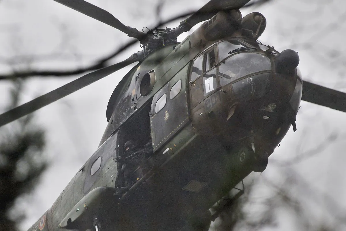 Armed securtiy forces fly overhead in a military helicopter in Dammartin-en-Goele, northeast of Paris, Friday Jan. 9, 2015. French security forces swarmed this small industrial town northeast of Paris Friday in an operation to capture a pair of heavily armed suspects in the deadly storming of a satirical newspaper. (AP Photo/Thibault Camus)