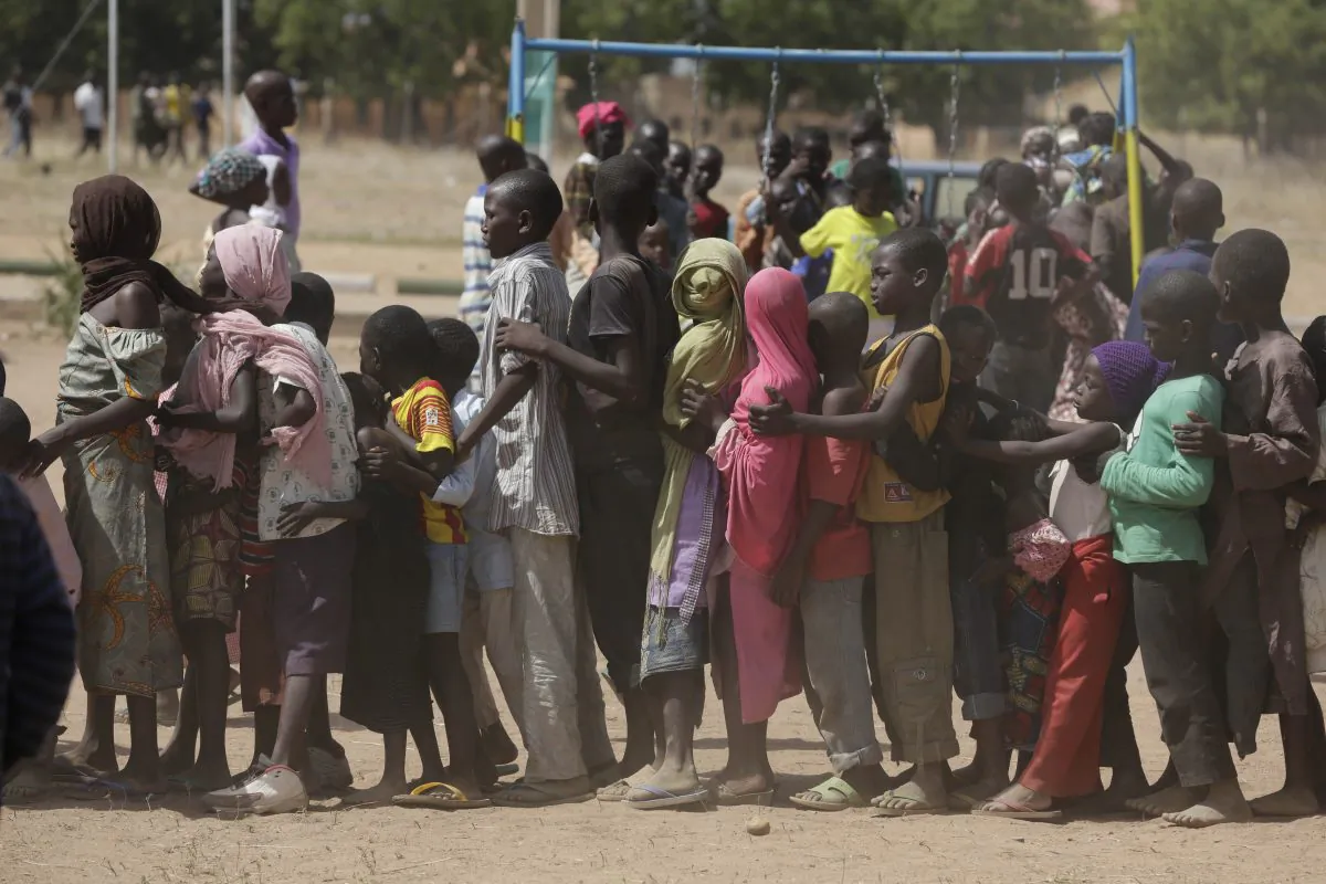 Children displaced after attacks by Boko Haram, line up in the camp of internal displace people, in Yola, Nigeria, on Nov. 27, 2014. (AP Photo/Sunday Alamba)