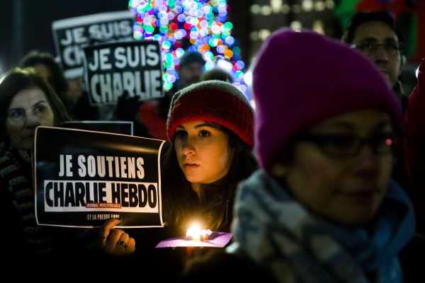 People gather to pay to pay tribute to victims of the terrorist attack against the French satirical weekly Charlie Hebdo, Friday, Jan. 9, 2015, at JFK Plaza, commonly known as Love Park, in Philadelphia. (AP Photo/Matt Rourke)