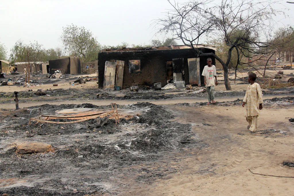 Children walk outside a charrred house in the remote northeast town of Baga on April 21, 2013, after two days of clashes between officers of the Joint Task Force and members of the Islamist sect Boko Haram on April 19 in the town near Lake Chad, 200 kms north of Maiduguri, in Borno State, Nigeria. (AFP/Getty Images)