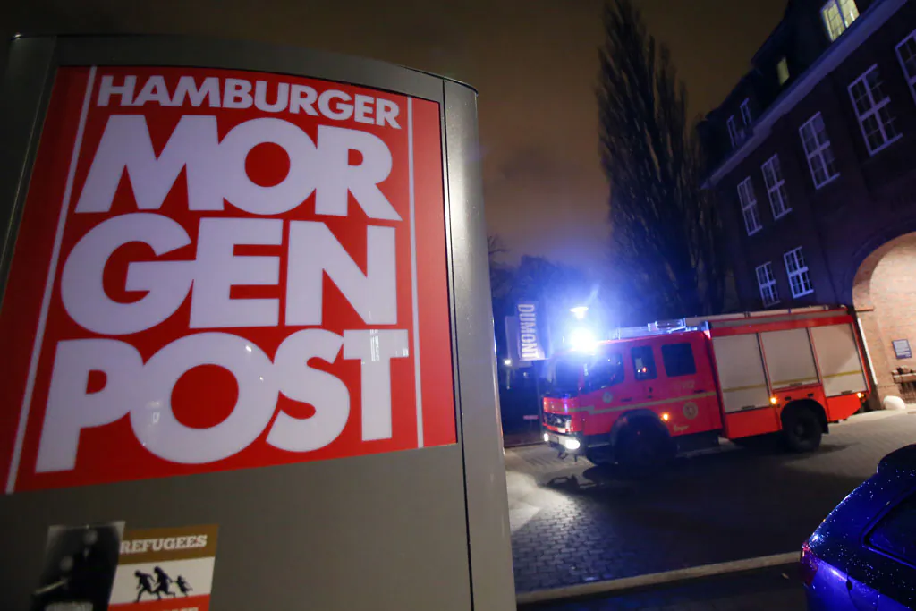 A firef truck sits outside the building of the 'Hamburger Morgenpost' in Hamburg, northern Germany, Sunday morning, Jan. 11, 2015. According to police fire broke out in an archive room of the paper after an arson attack. The newspaper ran caricatures of the Charlie Hebdo newspaper after the attack on Wednesday. (AP Photo/dpa, Bodo Marks)