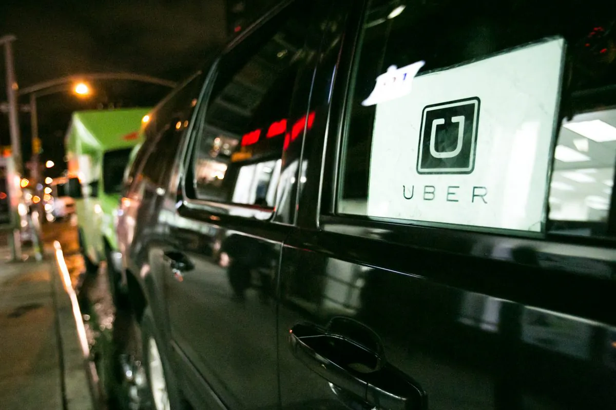The Uber logo is on a black SUV that is parked on Eighth Avenue in New York on Dec. 9, 2014. (Benjamin Chasteen/Epoch Times)
