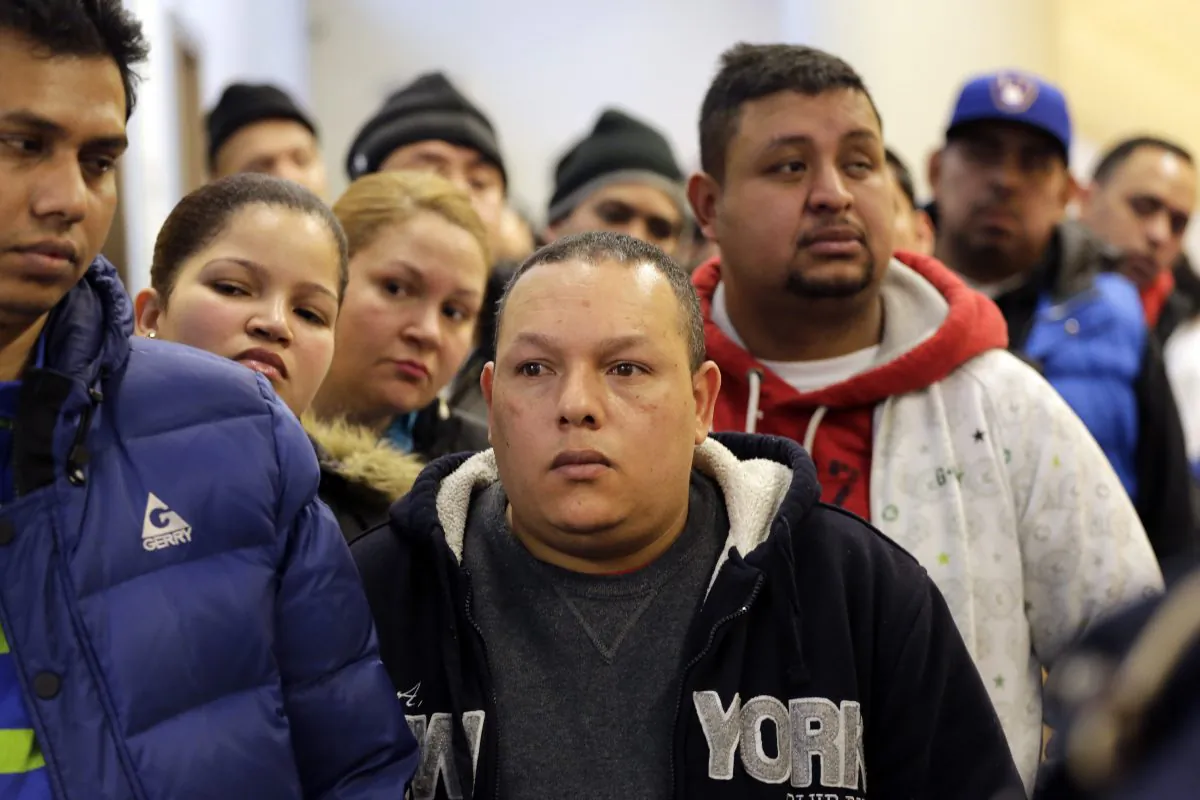 People wait in line to apply for municipal identification cards on the first day they are available at the Bronx Library Center in New York on Monday, Jan. 12, 2015. The card is aimed at those who don't currently have an ID. That includes an estimated 500,000 immigrants in the city without legal documentation. (AP Photo/Mark Lennihan)