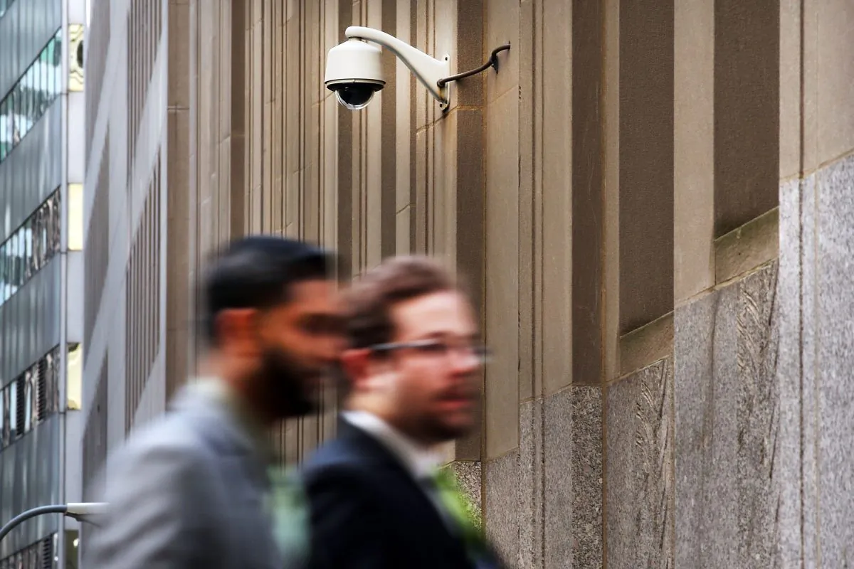 People walk by a surveillance camera along a street in the Financial District in New York on April 24, 2013. (Spencer Platt/Getty Images)