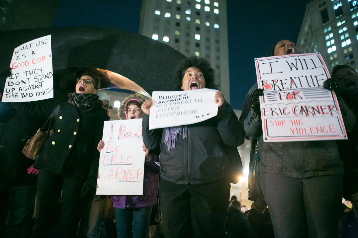 Protesters hold signs demanding justice for Eric Garner during a rally at Foley Square Park in New York City on Dec. 4, 2014. (Benjamin Chasteen/Epoch Times)