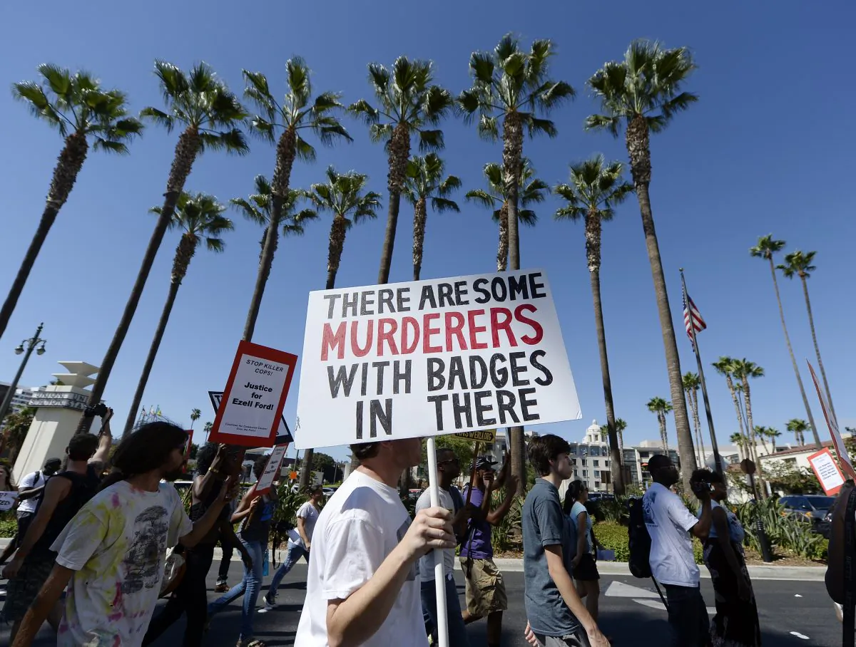 In this file photo, demonstrators march in downtown Los Angeles protesting the police shooting death of 24-year-old Ezell Ford earlier in the week August 17, 2014, in Los Angeles, California. (Kevork Djansezian/Getty Images)
