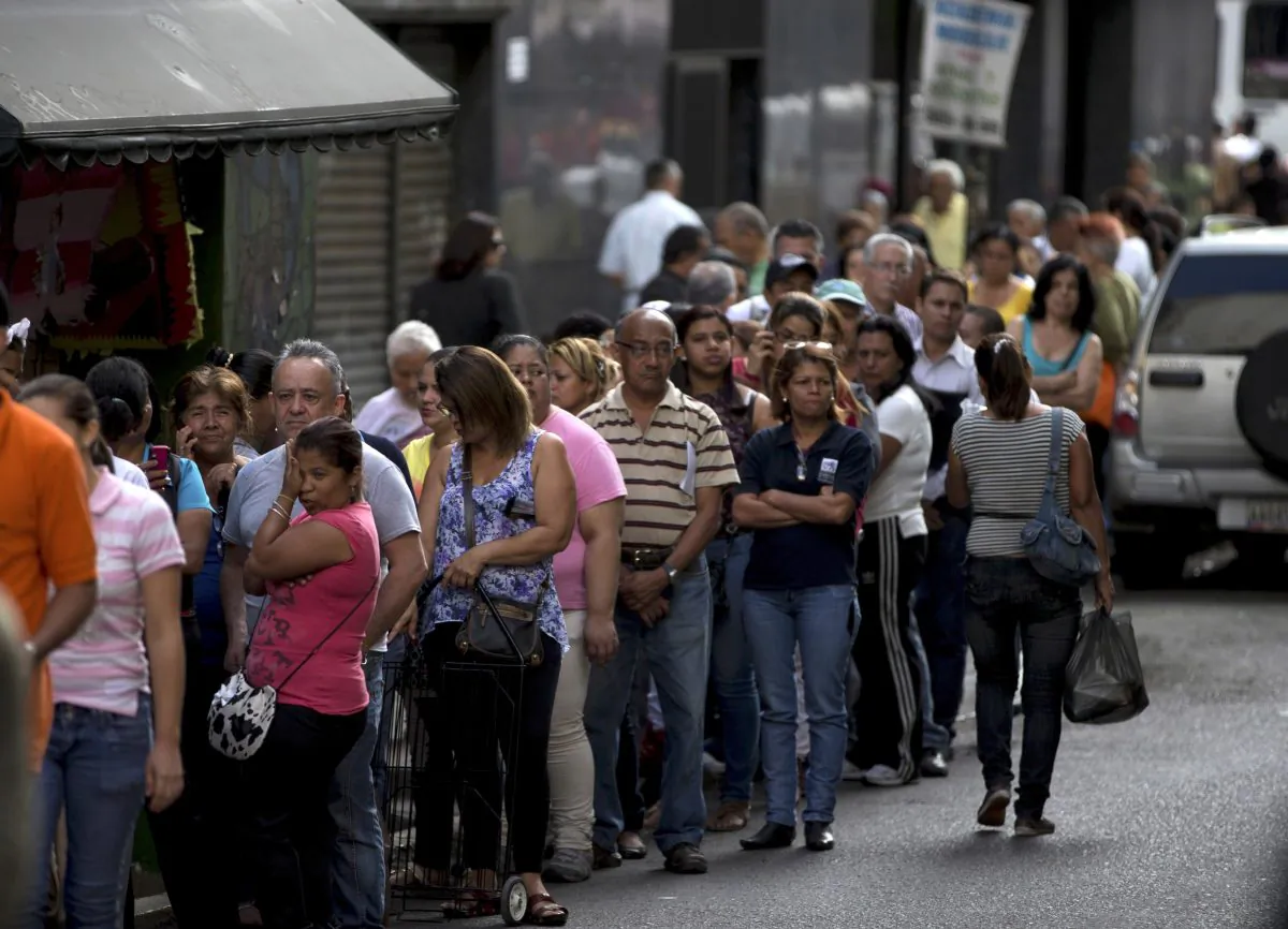 Shoppers queue outside of a supermarket in downtown Caracas, Venezuela, Thursday, Jan. 8, 2015. Venezuelans continue to struggle to find basic goods including detergent and sugar. Most of the shortages in Venezuela are driven in part by the country's tight currency controls, which make it hard to get dollars at a subsidized rate for imports while creating a thriving black market for currency. (AP Photo/Fernando Llano)