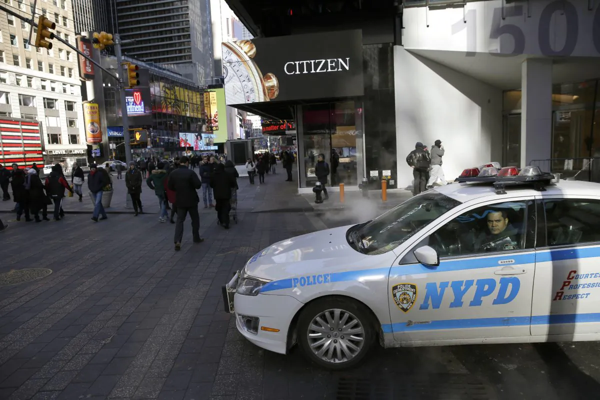 A policeman looks out the window of his patrol car in Times Square in New York. (AP Photo/Seth Wenig)