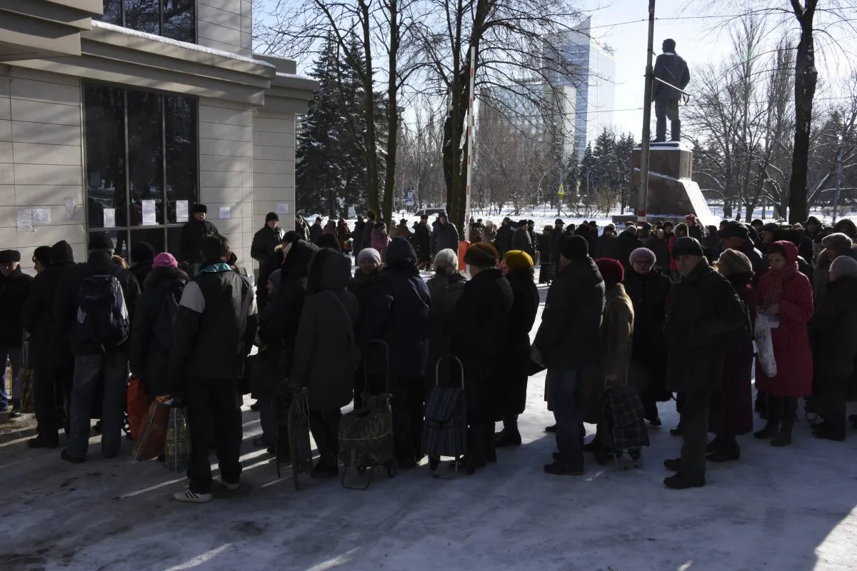 People queue to receive humanitarian aid from the charitable foundation of Ukrainian billionaire Rinat Akhmetov, whose vast wealth is founded on the industrial output of Donetsk coal-rich region, in Donetsk, Eastern Ukraine, Tuesday, Jan. 13, 2015. Akhmetov is contentious figure in eastern Ukraine. Although a major provider of employment, he is regarded with profound suspicion by much of the impoverished local population. Still, his standing improves with every consignment of goods that reaches separatist-held regions. Amnesty International said it received reports before the New Year holidays of volunteer battalions fighting alongside Ukrainian government forces of preventing the Akhmetov convoys from getting through. The battalion justified their actions by arguing that the food and clothes in the trucks could ultimately help to support the separatist cause, Amnesty says. (AP Photo/ Mstyslav Chernov)