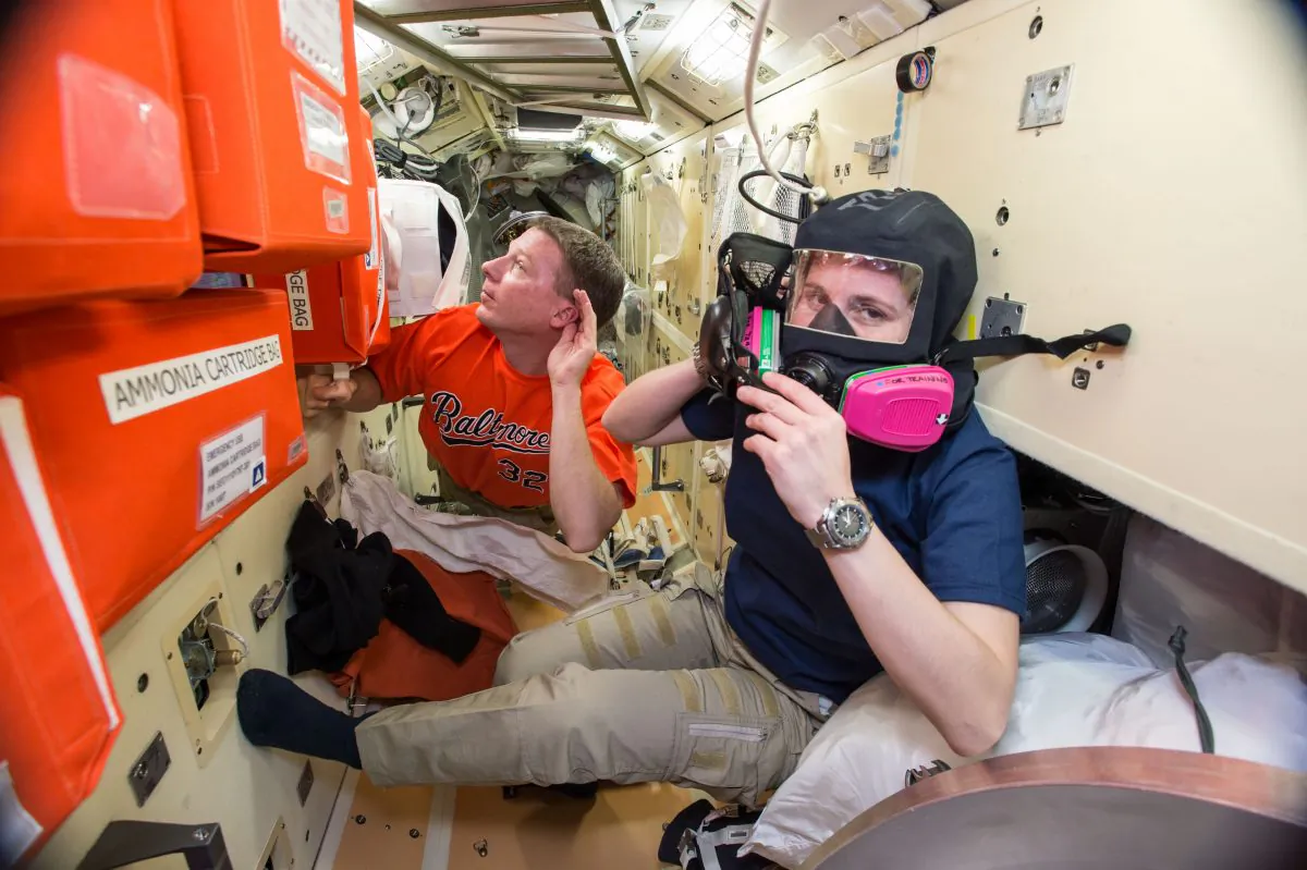 Image provided by NASA taken during a training exercise, US astronaut Terry Virts (L), assists European Space Agency astronaut Samantha Cristoforetti with emergency training aboard the International Space Station, on Dec. 1, 2014. Astronauts evacuated the US section of the International Space Station and moved to its Russian module after a problem emerged Wednesday, Jan. 14, 2015. (AP Photo/NASA)