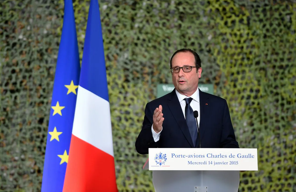 French President Francois Hollande reviews the troops during his visit on the French nuclear aircraft carrier Charles de Gaulle to present his New Year wishes to the French military forces, Wednesday, Jan.14, 2015, off the coast of Toulon, southern France. France ordered prosecutors around the country to crack down on hate speech, anti-Semitism and glorifying terrorism and announced Wednesday it was sending an aircraft carrier to the Mideast to work more closely with the U.S.-led coalition fighting Islamic State militants. (AP Photo/ Anne Christine Poujoulat /Pool)