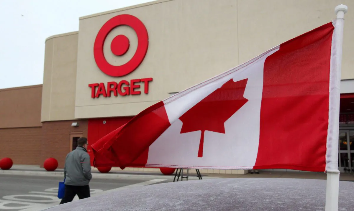 In this March 5, 2013 photo, a Canadian flag flies on the car of a customer's car parked in front of a Target store in Guelph, Ontario. On Thursday, Jan. 15, 2015, Target said it plans to exit Canada, citing the company didn't foresee operations being profitable there until at least 2021. (AP Photo/The Canadian Press, Dave Chidley)