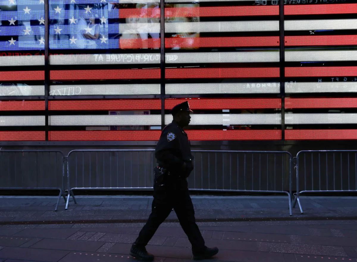 A police officer walks through Times Square in New York on Jan. 8, 2015. In bustling Times Square, where scores of tourists wander through streets clogged with traffic and hawkers selling trinkets, low-level enforcement activity had all but grinded to a halt. (AP Photo/Seth Wenig)