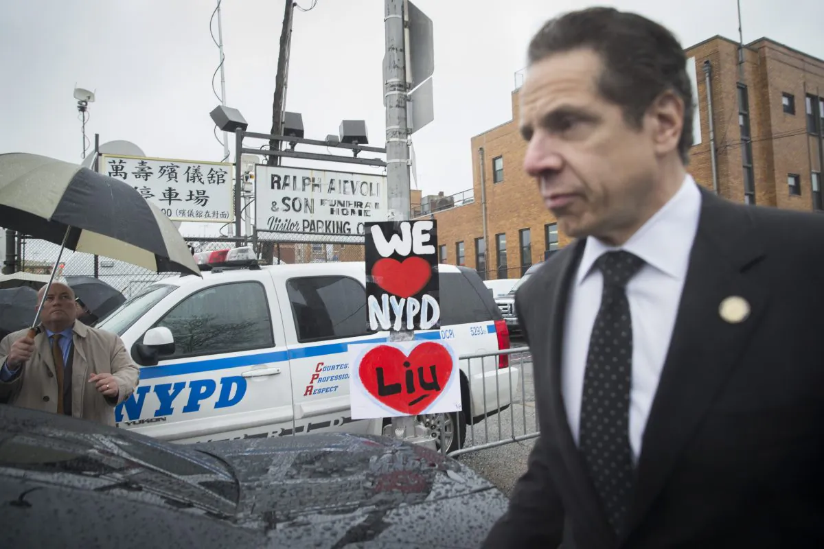 New York Gov. Andrew Cuomo (R) leaves the wake of New York Police Department officer Wenjian Liu at Aievoli Funeral Home in New York on Saturday, Jan. 3, 2015. Black law enforcement organizations in New York criticize Cuomo for not discussing legislative proposals with them. (AP Photo/John Minchillo)