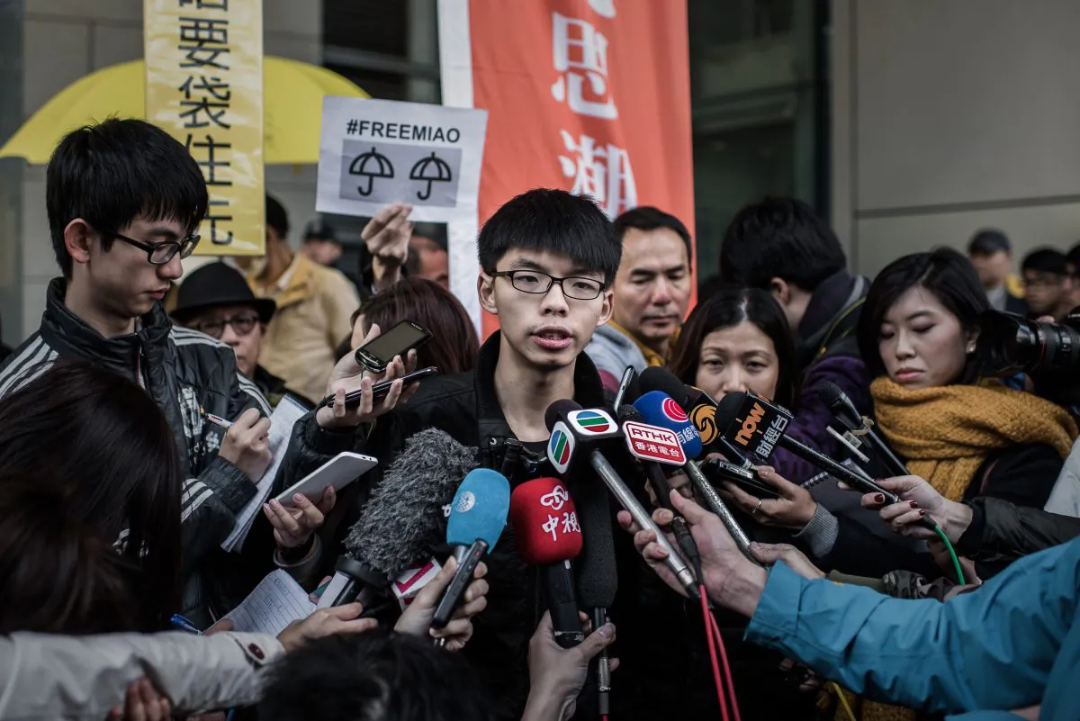 Student activist Joshua Wong (C) talks to the media outside the Wanchai police station in Hong Kong on Jan. 16, 2015. (Philippe Lopez/AFP/Getty Images)