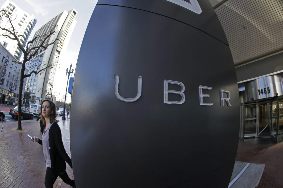 In this Tuesday, Dec. 16, 2014 photo, a woman leaves the headquarters of Uber in San Francisco. (AP Photo/Eric Risberg)
